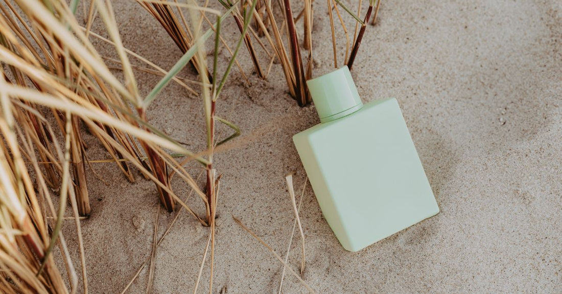 A minimalist glass fragrance bottle on a white surface, illustrating how to choose fragrance UK for daily routines.