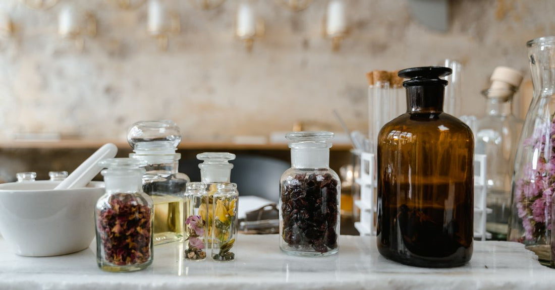 A flatlay of three minimalist skincare jars and a tube on a white marble surface, representing a complete balms and moisturisers buying guide.
