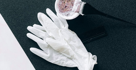 A flatlay of mess-free hair dye tools including an applicator bottle, tint brush, and mixing bowl, illustrating how to dye hair at home without mess.