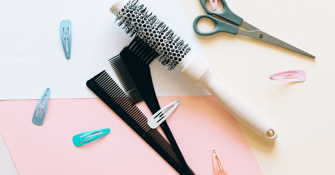 A flatlay arrangement of professional hair brushes, combs, and dressing needles on a light background, demonstrating how to choose brushes, combs & needles for grooming.