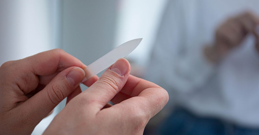 Close-up of a high-quality emery board nail file on a neutral surface, demonstrating how to use a nail file correctly for smooth nail shaping.