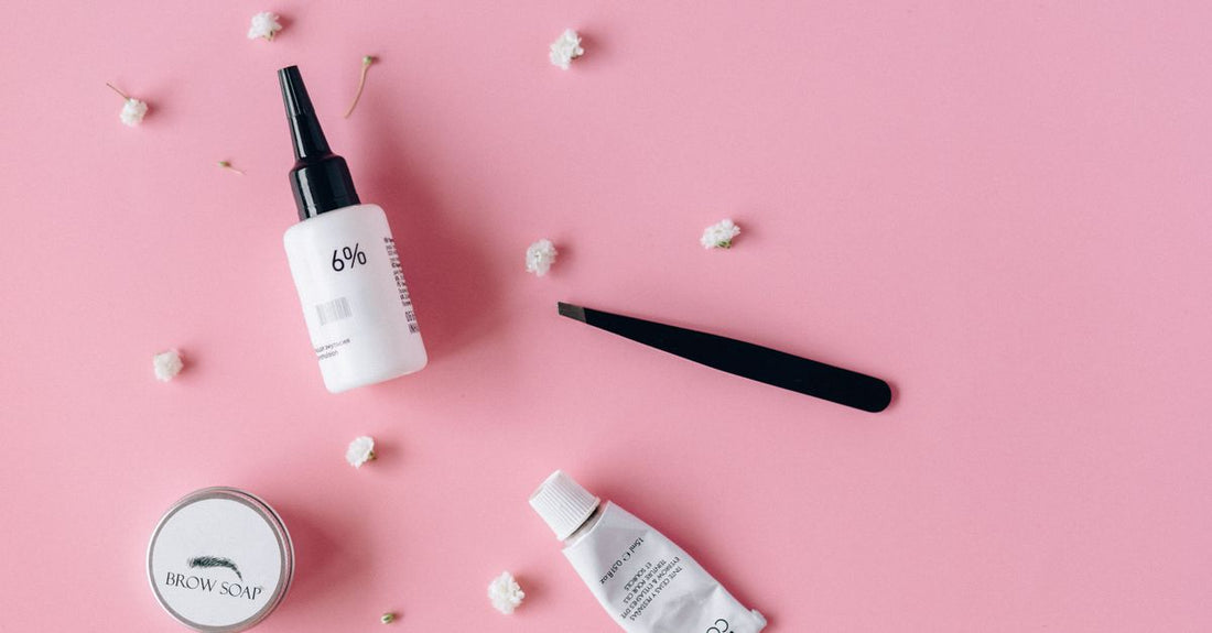 A tube of clear eyebrow gel on a white beauty flatlay, representing the best eyebrow gel for natural look.