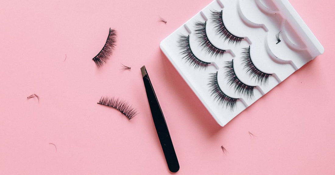 A flatlay of various false eyelash styles including natural, wispy, and dramatic on a white background, illustrating how to choose false lashes UK.