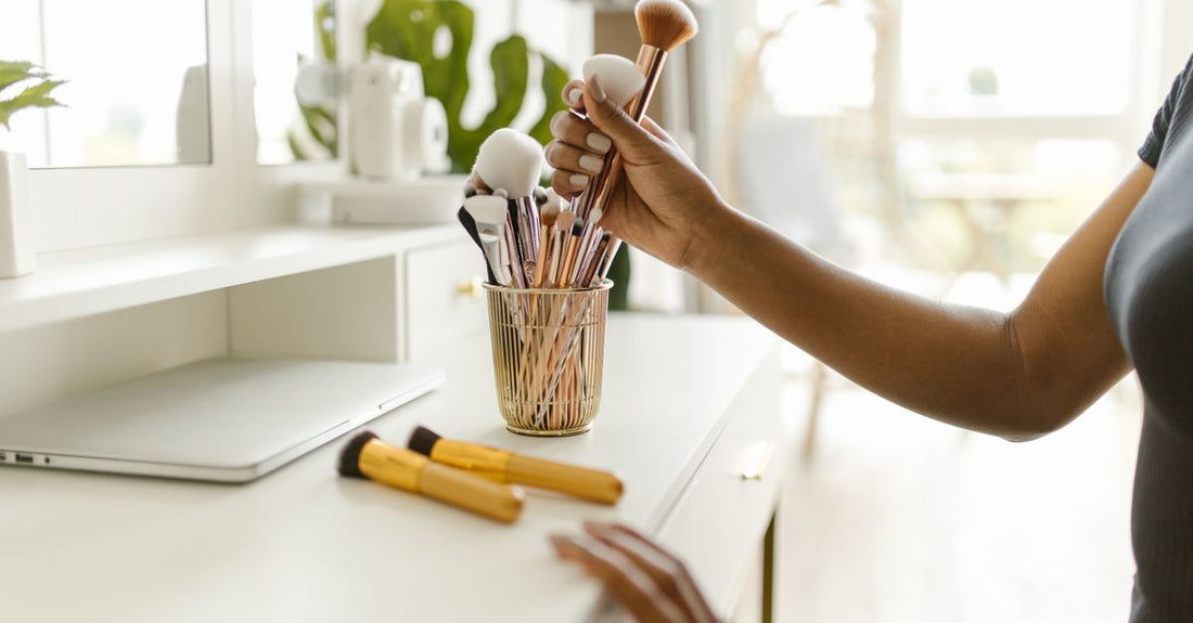 A collection of clean, organised makeup storage containers including clear acrylic drawers and sealed jars, demonstrating how to store makeup to keep it fresh.