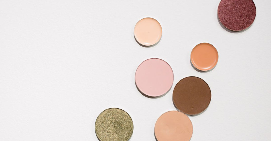 A flatlay of best eyeshadow UK 2026 palettes with vibrant colour swatches on a marble background.