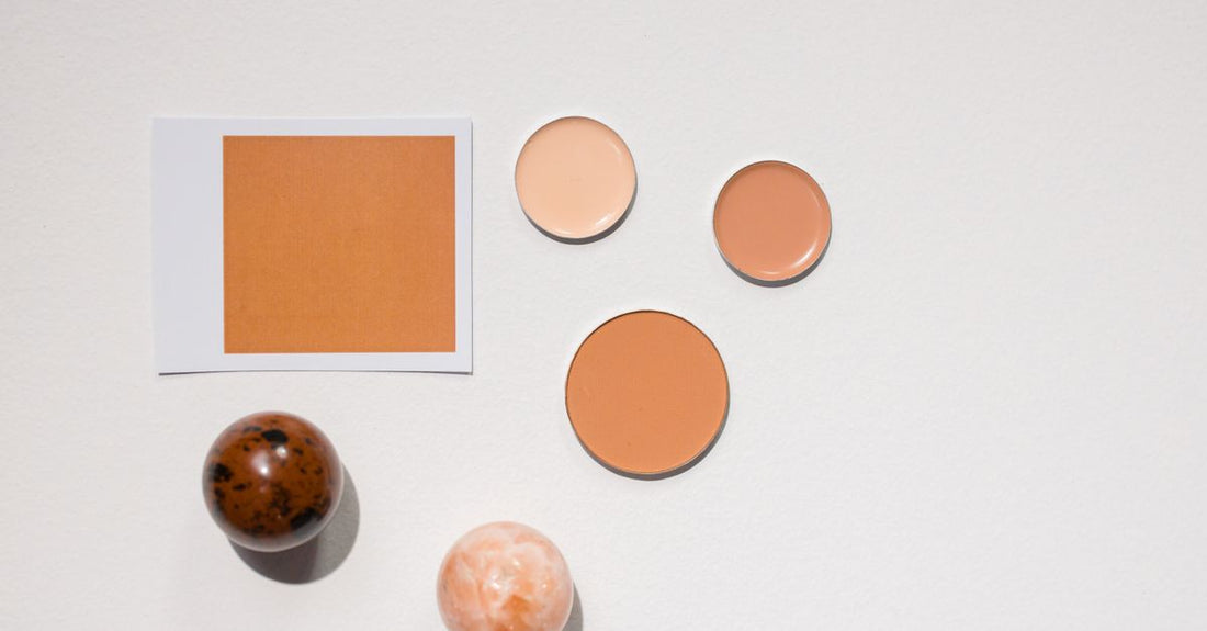 A flatlay of different foundation bottles on a white surface, illustrating how to choose foundation UK.
