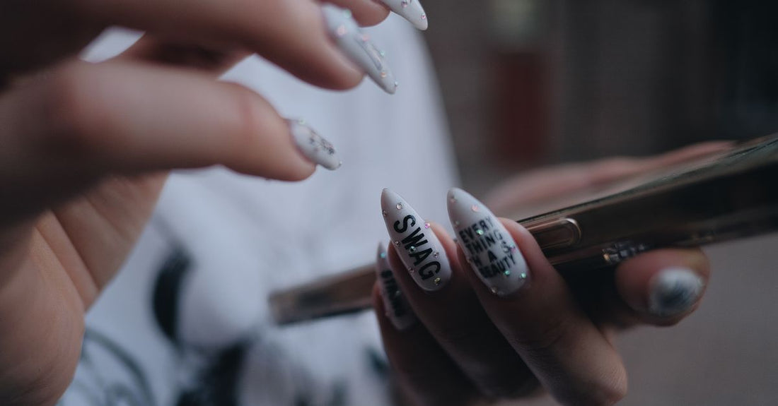 A flatlay of a 2026 nail decoration kit with rhinestones, charms, and tools on a white background, showcasing the best decoration kits 2026.