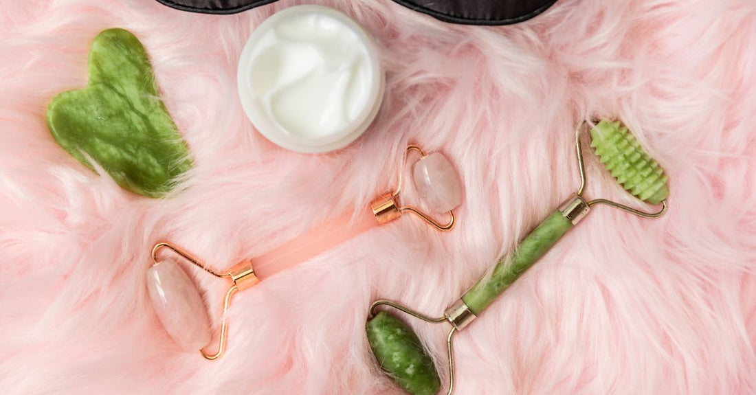 A selection of the best accessories 2026, including a facial roller and a dermaplaning tool, arranged on a marble surface.