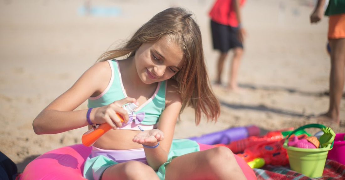 A selection of body sunscreen bottles on a beach towel under British summer sunlight, illustrating how to choose body sunscreens.