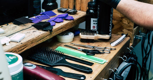 Flatlay of hair styling products including cream, wax, comb, and brush on a neutral background for a styling products buying guide UK.