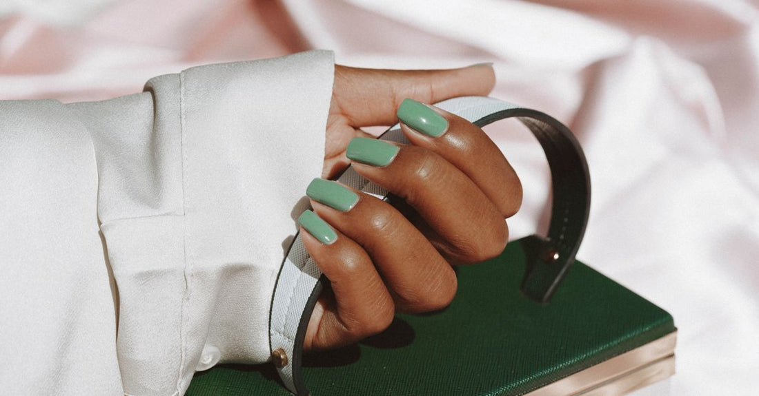 A flatlay of colourful press-on false nails and essential manicure accessories on a white background, part of a false nails & accessories buying guide.