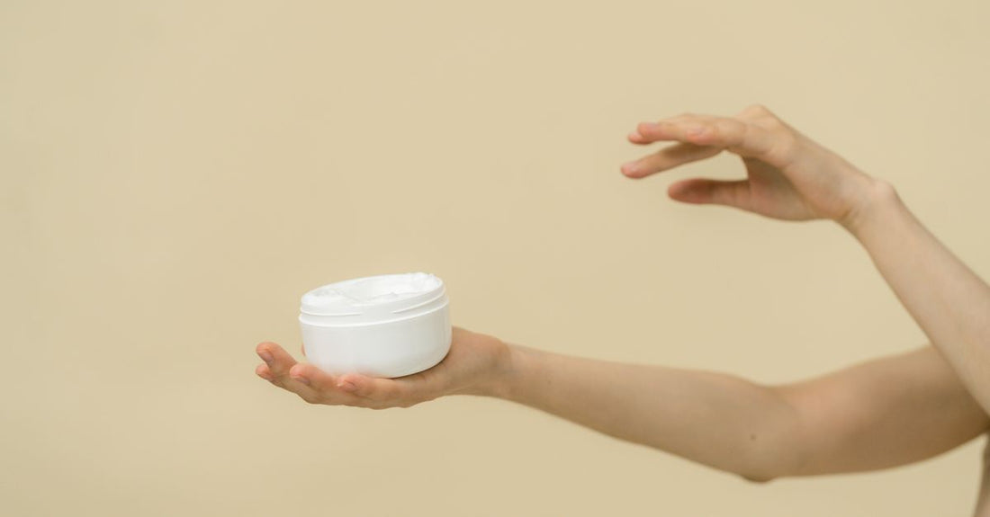 A jar of organic wrinkle cream for face surrounded by natural botanical ingredients on a light background.
