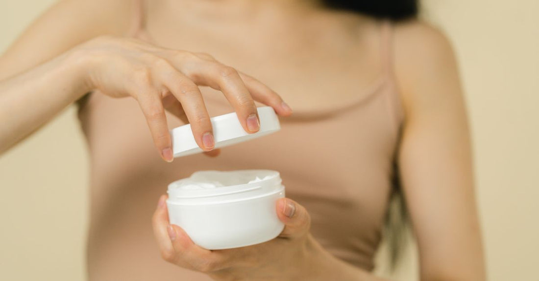 Night cream vs day cream: two white moisturiser jars side by side on a marble surface, one labelled night, the other day.