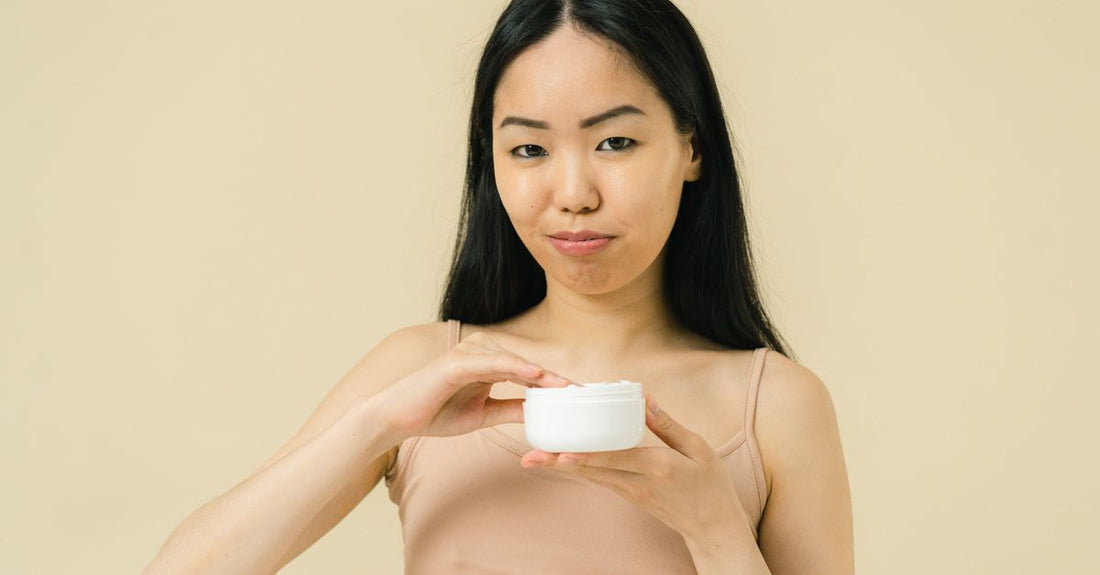 A jar of cica cream, best cica cream for acne scars, on a clean white background with the lid off, showing a smooth green-tinted balm texture.