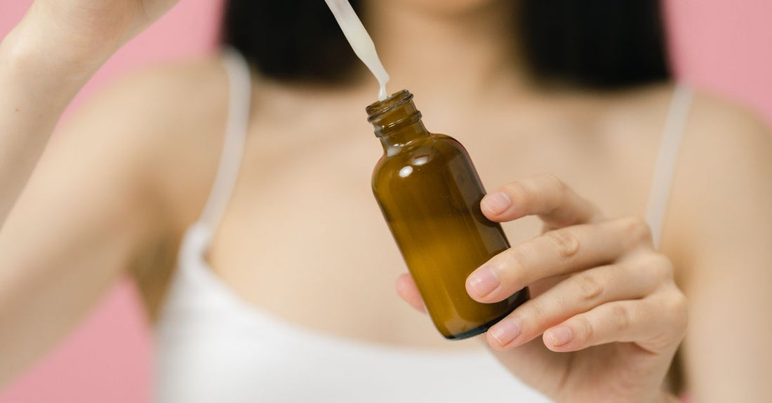 A sleek scalp treatment serum bottle and silicone massager on a bathroom shelf, representing the best scalp treatments UK 2026 routine.