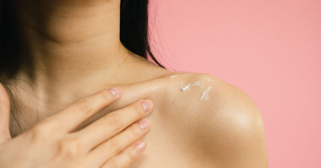 An open jar of whipped body butter on a marble surface, illustrating the rich texture discussed in this body butters buying guide.